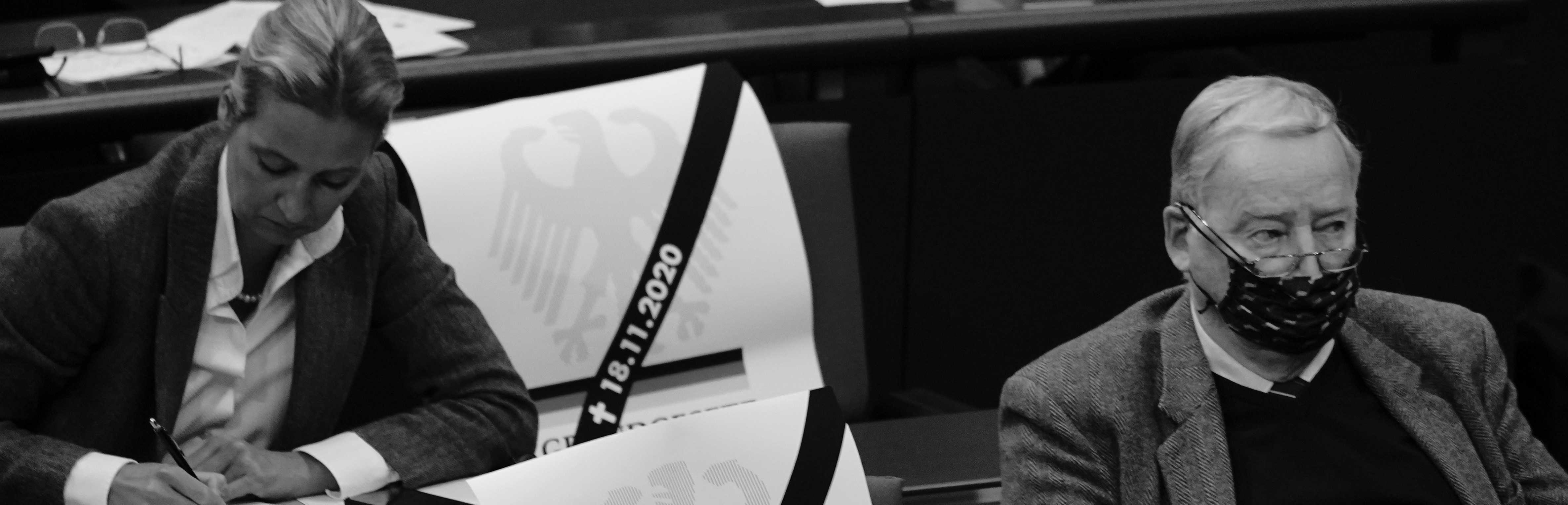 Abgeordnete der AfD auf Sitzen im Bundestag während der Debatte um das Infektionsschutzgesetz 2020. Neben ihnen Plakate mit der Aufschrift Grundgesetz und Trauerflor